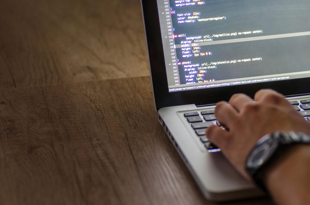 Software developer writing PHP code on a laptop, representing backend development at The Gate Solution